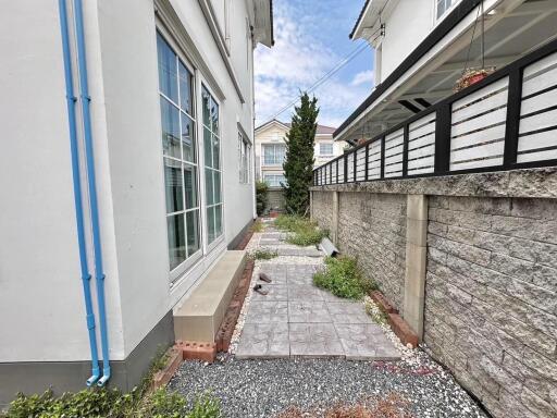 Narrow side yard with paving stones and adjacent houses