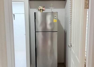 Compact modern kitchen with a stainless steel refrigerator