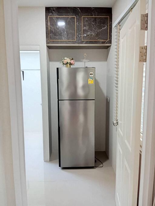 Compact modern kitchen with a stainless steel refrigerator