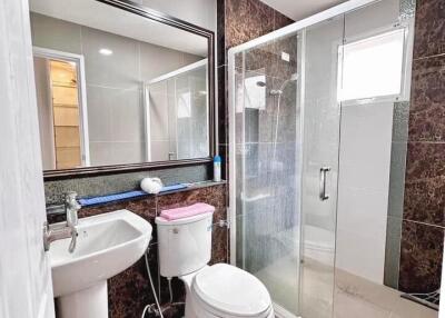 Modern bathroom with glass enclosed shower, large mirror and contemporary fixtures