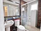 Modern bathroom with glass enclosed shower, large mirror and contemporary fixtures