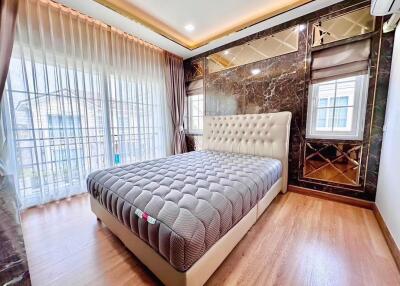 Luxurious bedroom with tufted bed and large windows