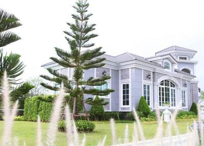 Exterior view of a modern home with a manicured lawn and decorative trees