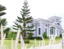 Exterior view of a modern home with a manicured lawn and decorative trees