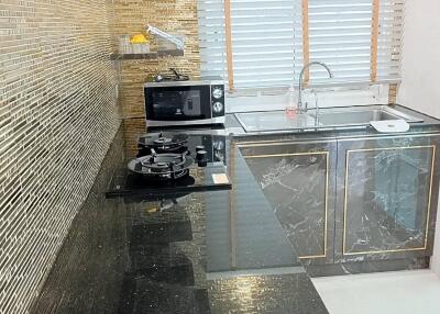 Modern kitchen with black granite countertops and mosaic tile backsplash