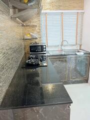 Modern kitchen with black granite countertops and mosaic tile backsplash