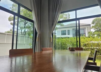 Spacious dining room with high ceiling and large windows