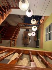 Aerial view of a multi-story home interior with a dining area and hanging lights