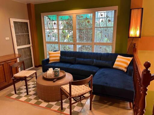 Living room with blue sofa, coffee table, and window