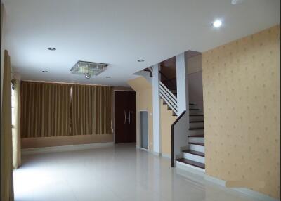 Spacious living room with staircase and large windows