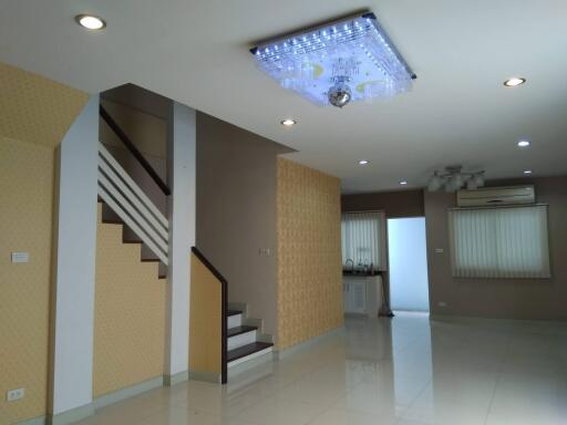 Modern living space with staircase and chandelier