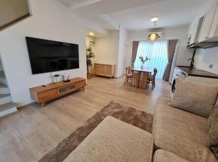 Modern living room with open dining area and visible staircase