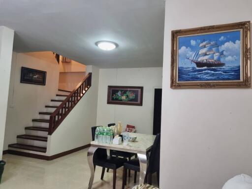 Dining area with table, chairs, and staircase