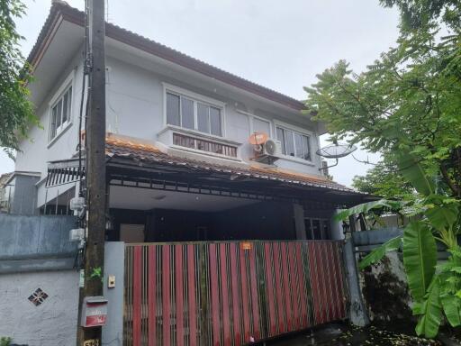 Exterior view of a two-story house with a gated entrance