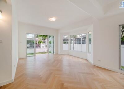 Spacious living room with large windows and wooden floor