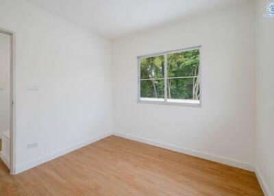 Empty bedroom with wooden floor and window view