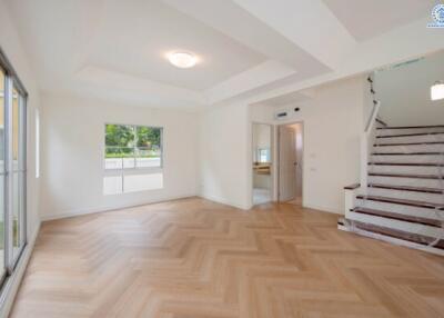 Spacious living room with wooden flooring and staircase