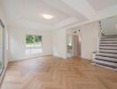 Spacious living room with wooden flooring and staircase