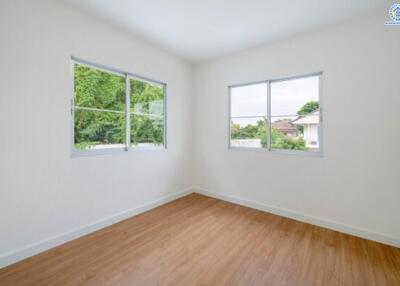 Empty bedroom with wooden flooring and large windows