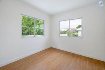 Empty bedroom with wooden flooring and large windows