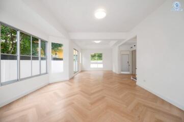 spacious living room with large windows and wooden flooring