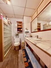 Modern bathroom with tiled walls and glass block divider