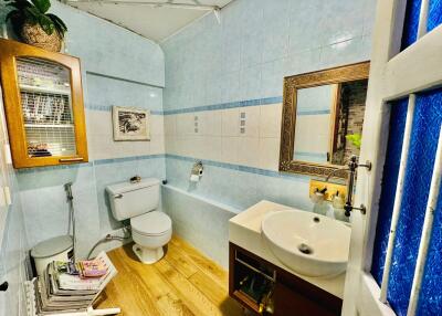 Modern bathroom with wood flooring and blue tile walls