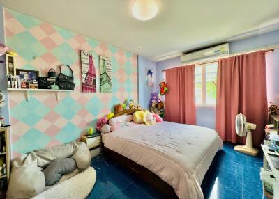 A colorful and cozy bedroom with a double bed and personal decor