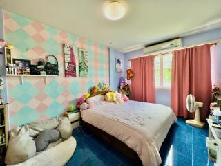 A colorful and cozy bedroom with a double bed and personal decor