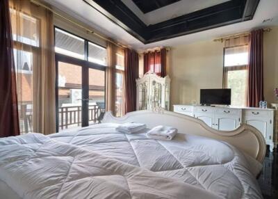 Spacious bedroom with large windows and a cozy bed