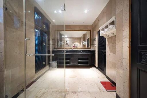 Modern bathroom with glass shower, double sink, and vanity mirrors