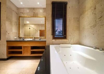 Spacious and luxurious bathroom with a large bathtub and wooden accents