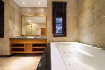 Spacious and luxurious bathroom with a large bathtub and wooden accents