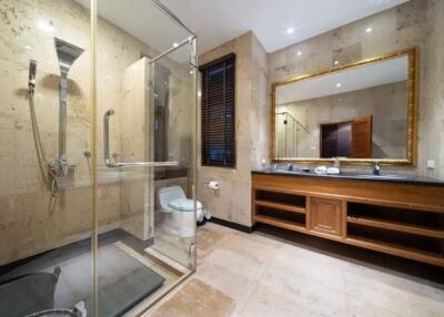 Modern and spacious bathroom with glass shower enclosure and large vanity mirror