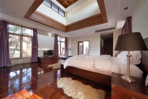 Spacious bedroom with large windows and polished wooden floor