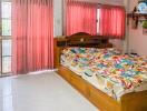 Bedroom with wooden bed and colorful bedspread