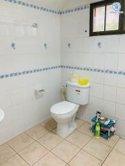 Bathroom with toilet and tiled walls