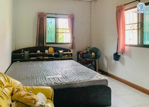 Bedroom with window curtains, bed, and seating