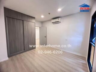 Modern empty bedroom with wooden flooring and a built-in wardrobe