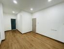 Empty room with wooden flooring and white walls