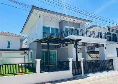 Modern two-story house with large windows and a balcony