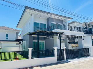 Modern two-story house with large windows and a balcony