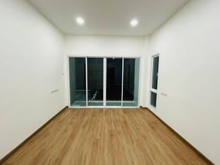 Spacious living room with wooden flooring and large windows