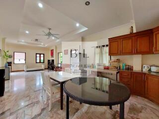 Spacious kitchen and dining area with wooden cabinets and marble flooring