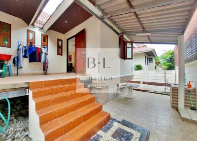 Covered outdoor area with tiled stairs and washing area