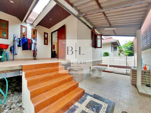 Covered outdoor area with tiled stairs and washing area