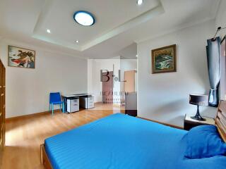 Spacious and well-lit bedroom with blue theme and office area