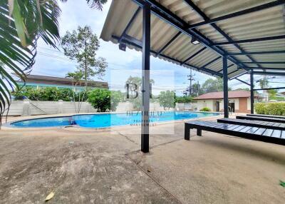 Covered patio area near swimming pool with seating