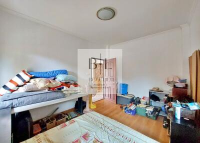 Bedroom with bed, wooden floor, and various items