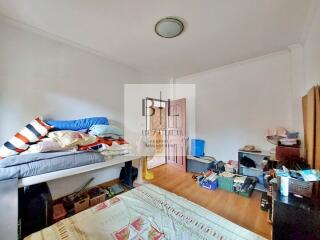 Bedroom with bed, wooden floor, and various items